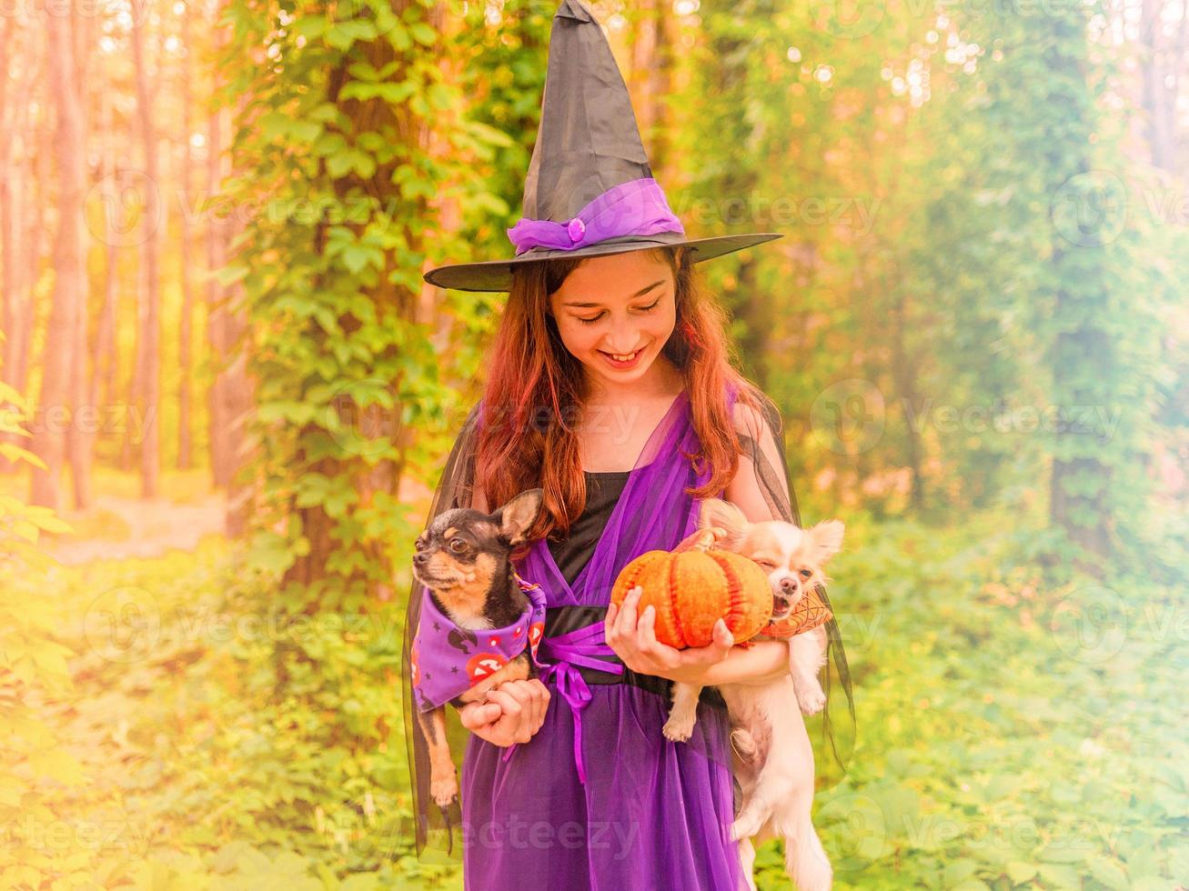 strega con una zucca. bambina in costume da strega all'aperto. foto