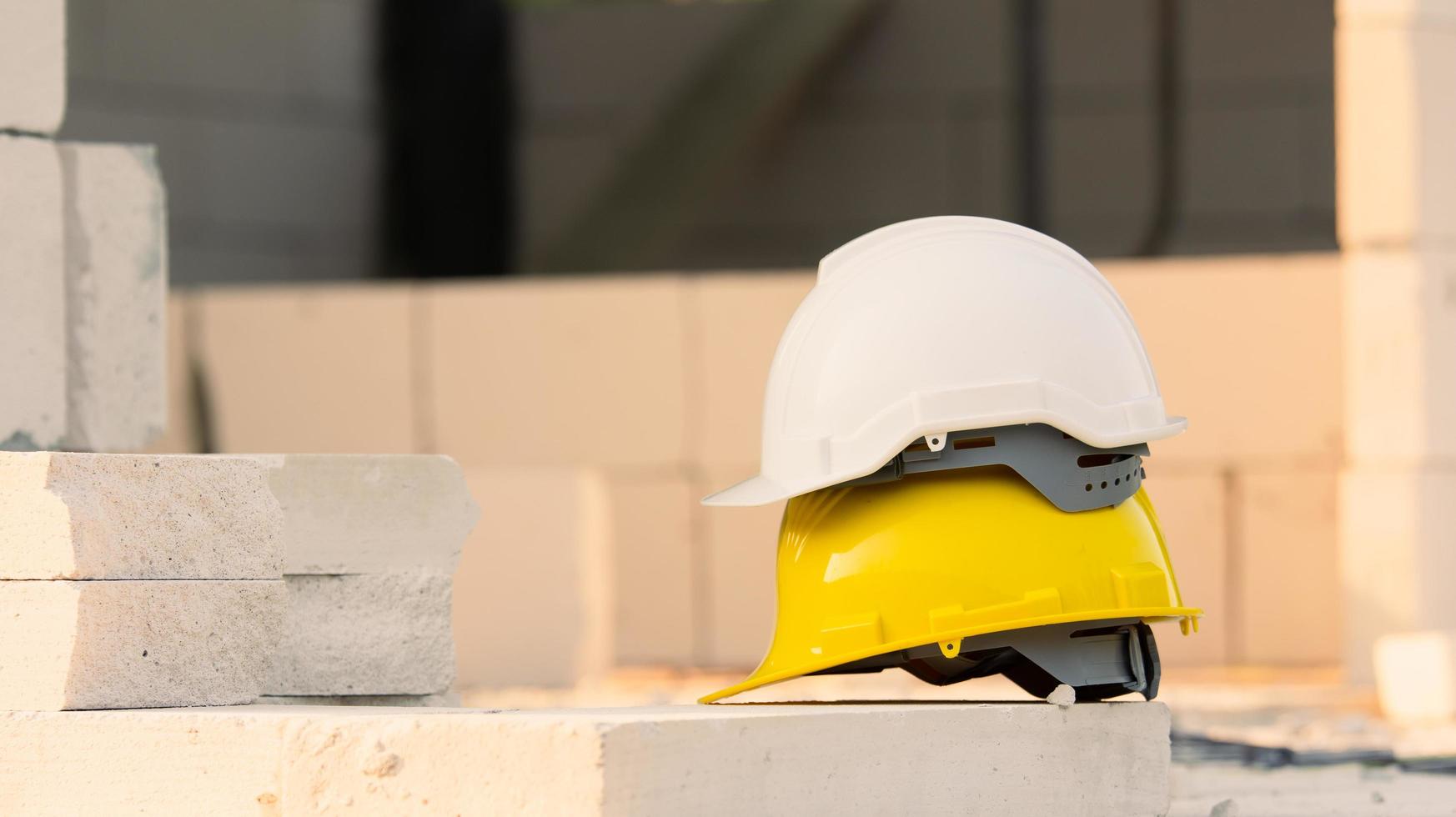 elmetto sullo sfondo della costruzione del sito, sicurezza del casco, festa del lavoro foto