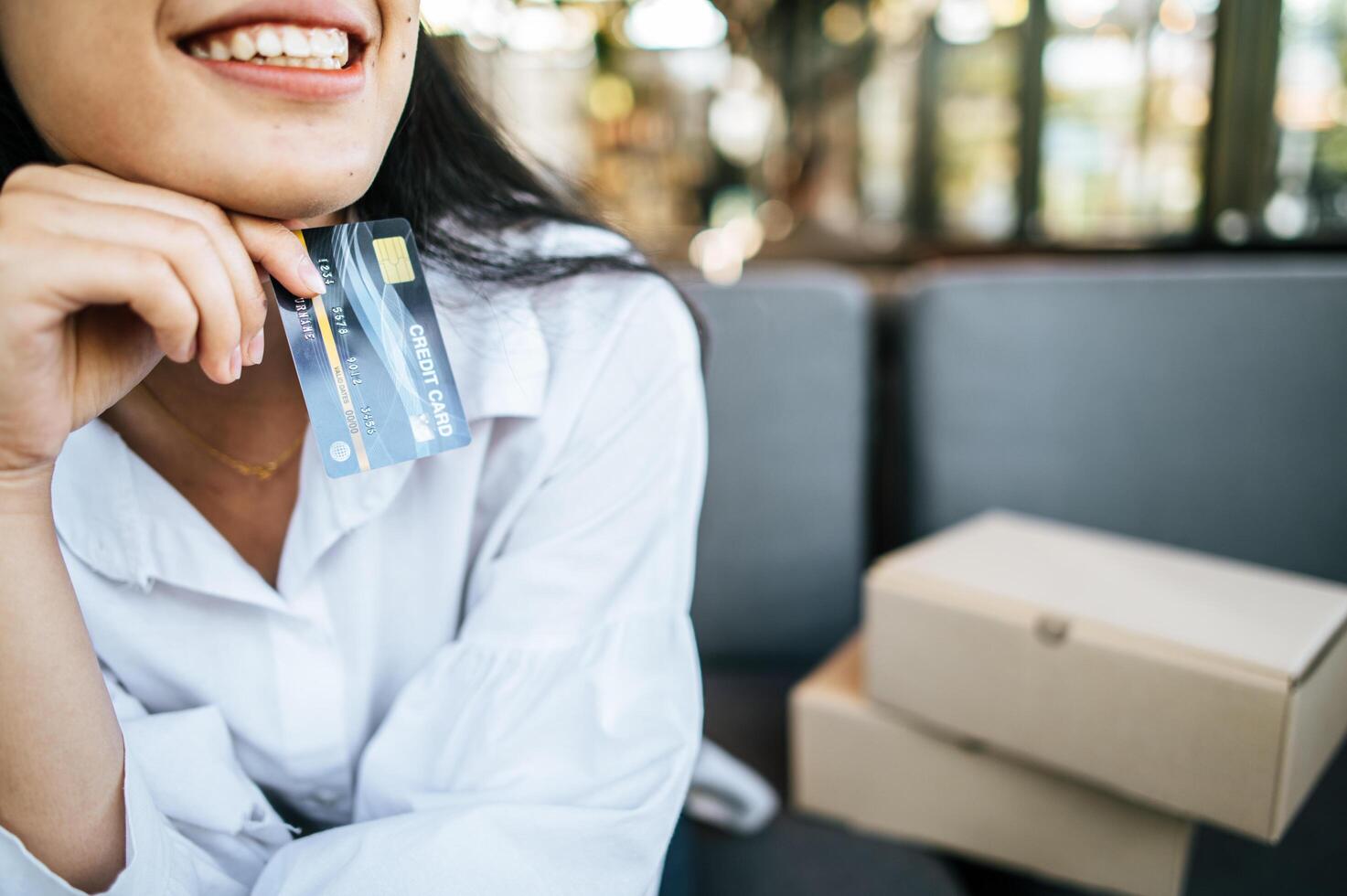 donna sorridente che tiene la carta di credito foto