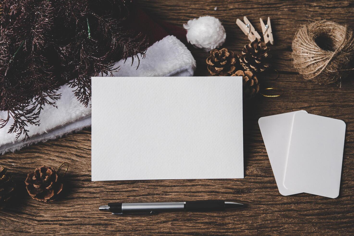 una carta bianca e una penna sono posizionate su legno. foto