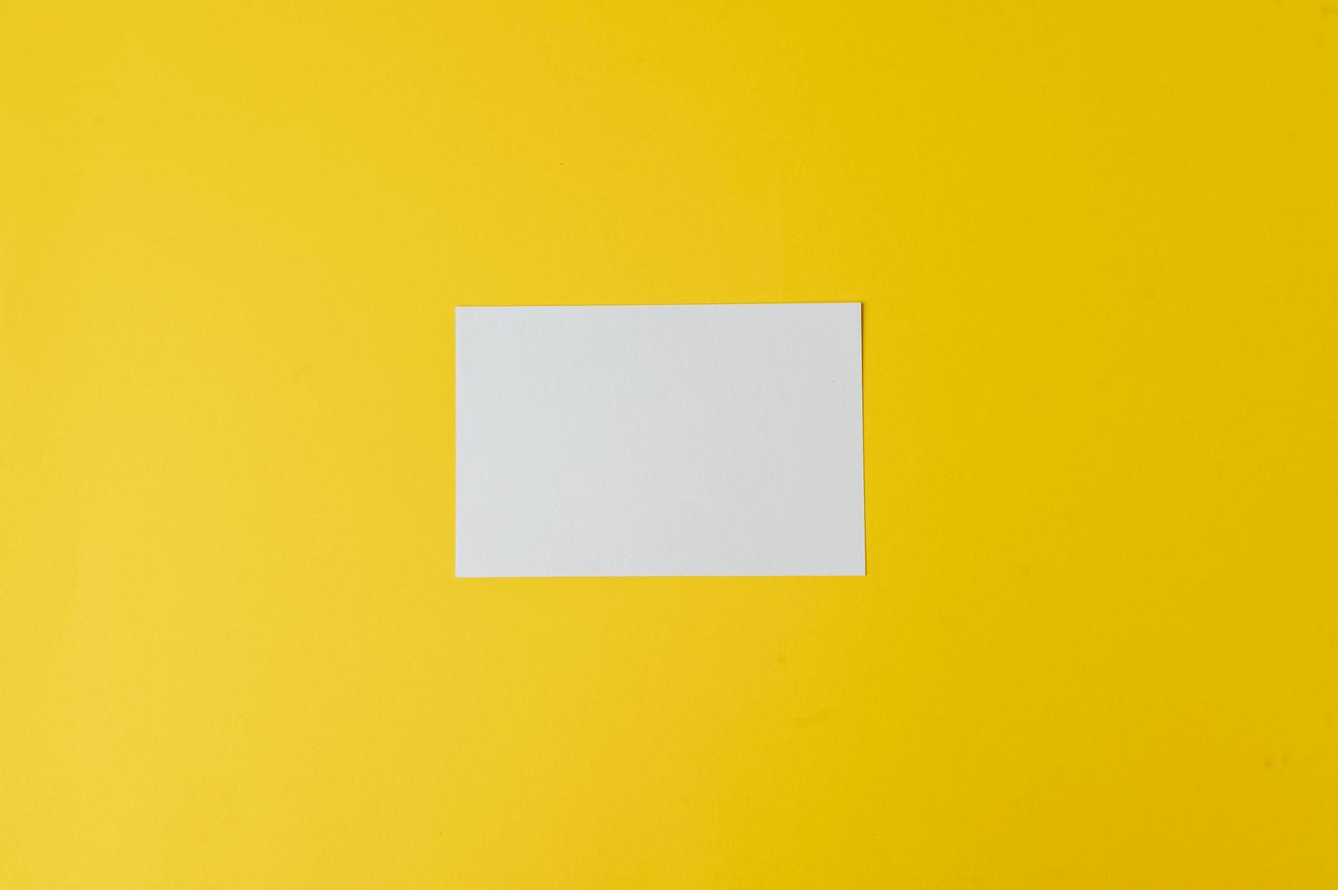 una carta bianca è posta su sfondo giallo foto