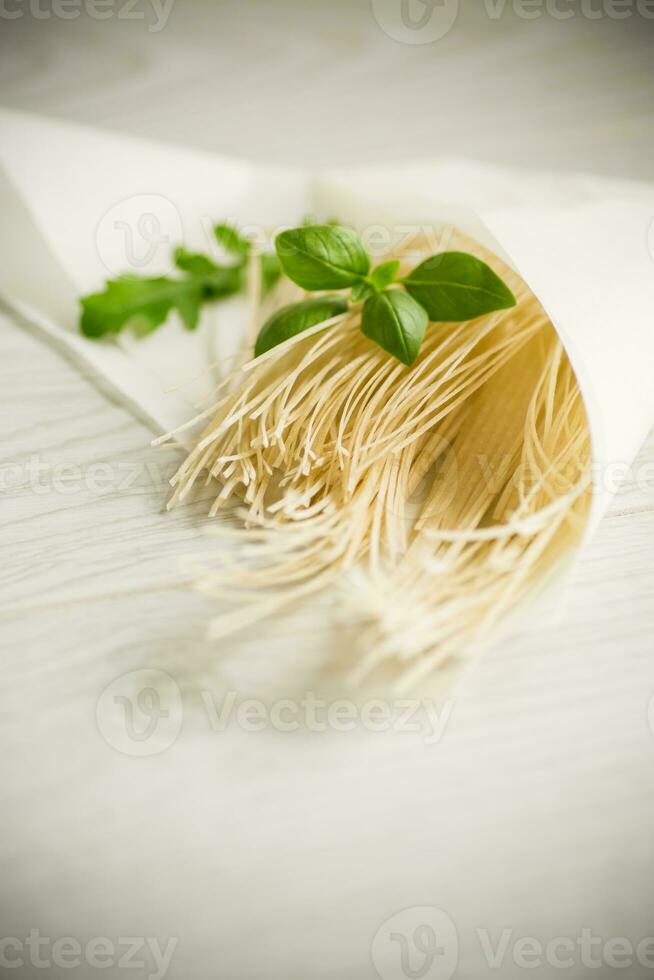 fatti in casa magro secco uovo tagliatelle nel carta Borsa con basilico foto