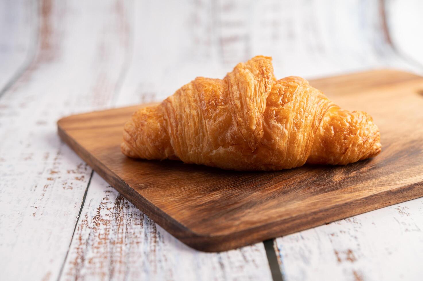 croissant su un tagliere di legno. messa a fuoco selettiva. foto