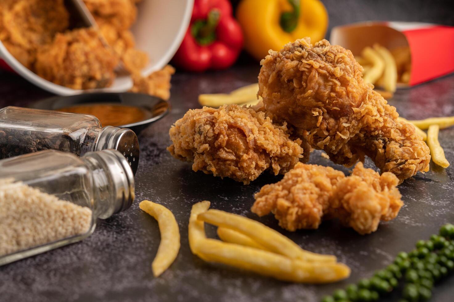 pollo fritto e patatine fritte sul pavimento di cemento nero. foto