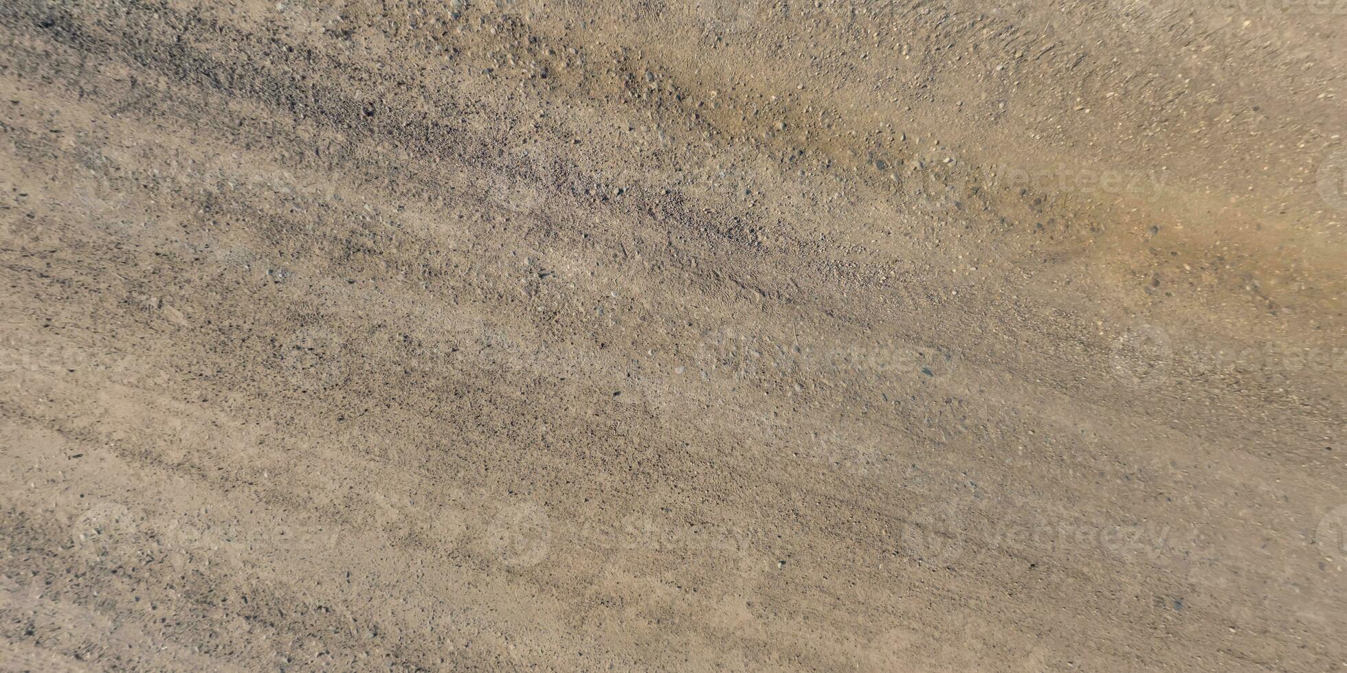 panorama di strada a partire dal sopra su superficie di ghiaia strada con auto pneumatico brani nel campagna foto