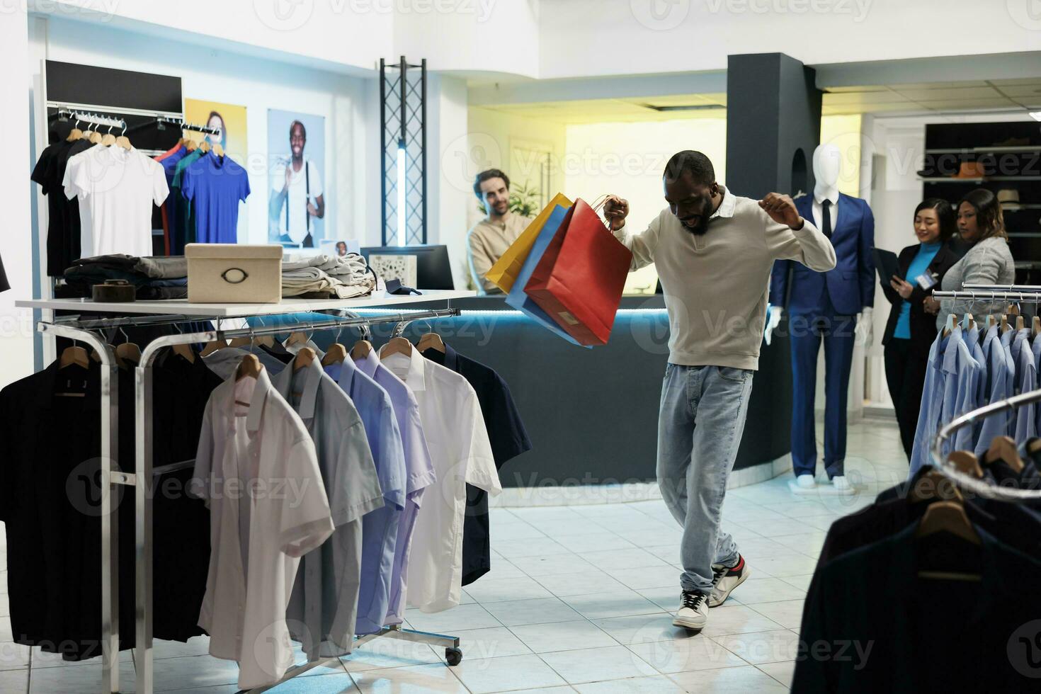 eccitato africano americano maniaco di shopping trasporto shopping borse e danza nel capi di abbigliamento negozio. moda boutique contento allegro cliente Tenere pacchi con abbigliamento e avendo divertimento foto