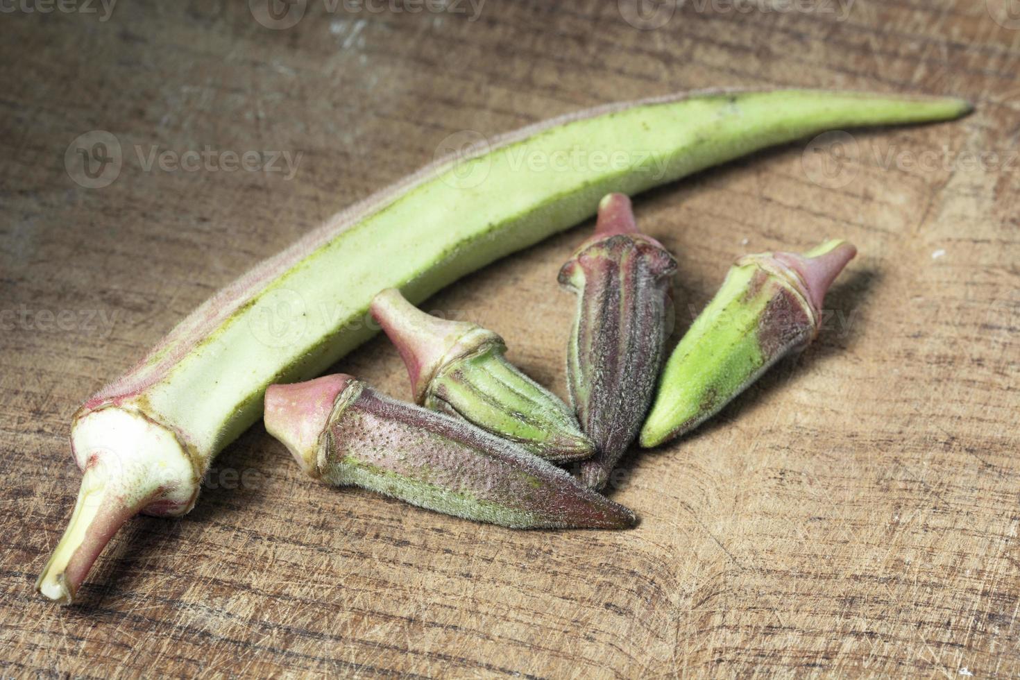 okra di grandi e piccole dimensioni okra su tavola di legno foto