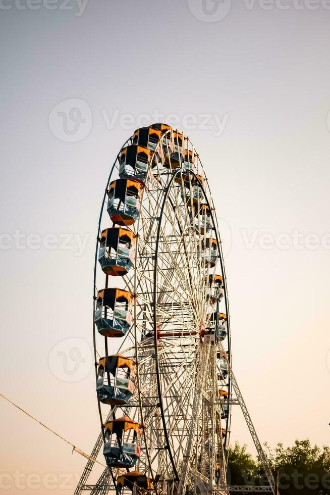 avvicinamento di multicolore gigante ruota durante Dussehra mela nel delhi, India. parte inferiore Visualizza di gigante ruota oscillazione. ruota panoramica con colorato cabine durante giorno volta. foto