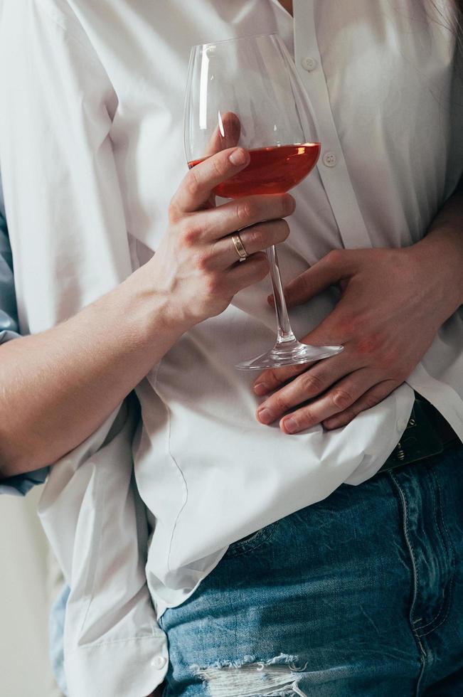 giovane coppia che si abbraccia e beve vino foto