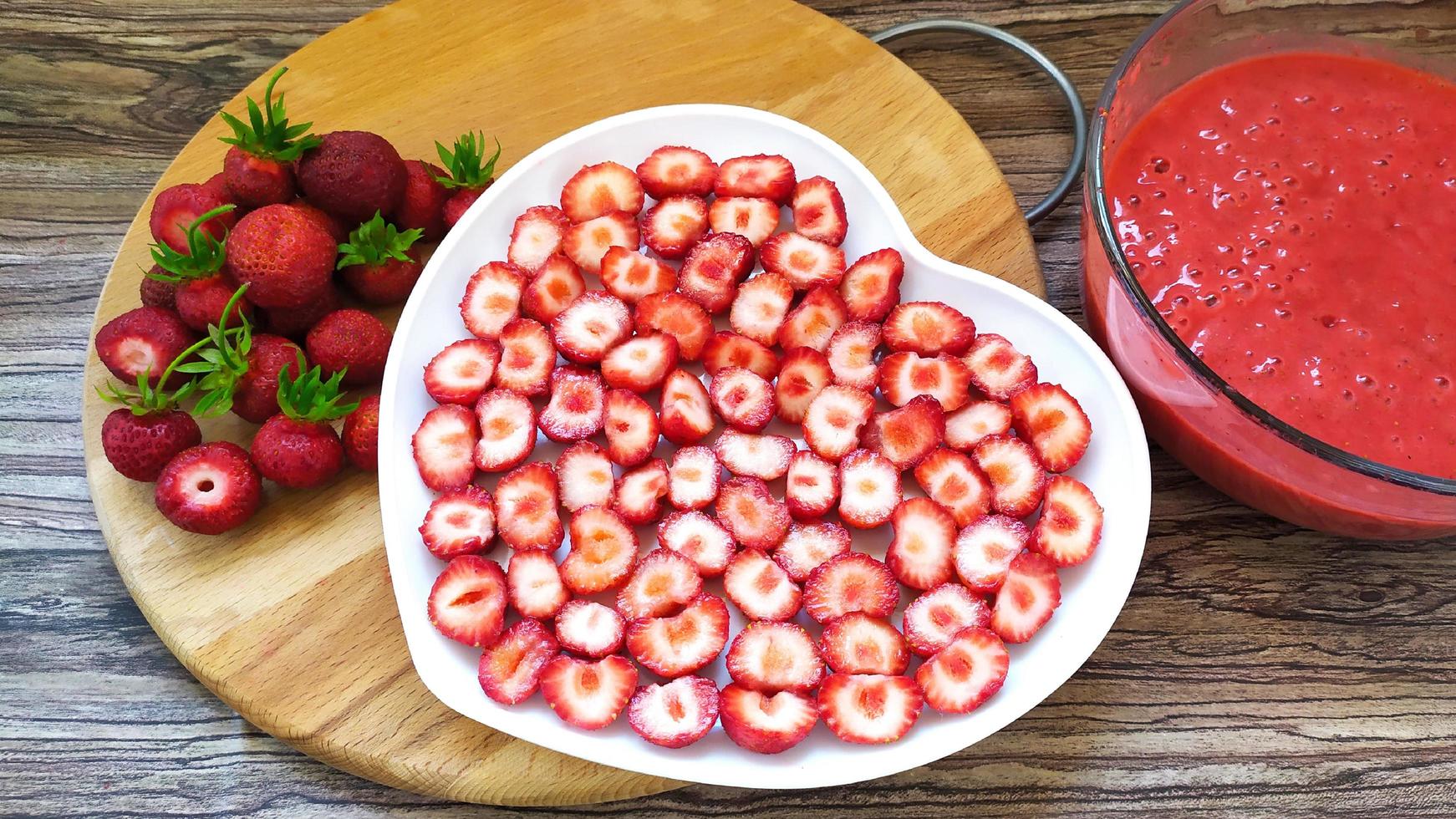 fette di fragola su un piatto bianco a forma di cuore foto