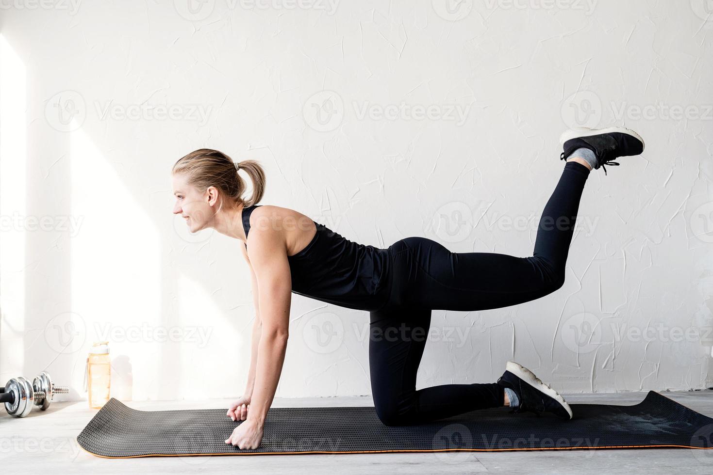 giovane donna bionda che si allena facendo esercizi per i glutei foto