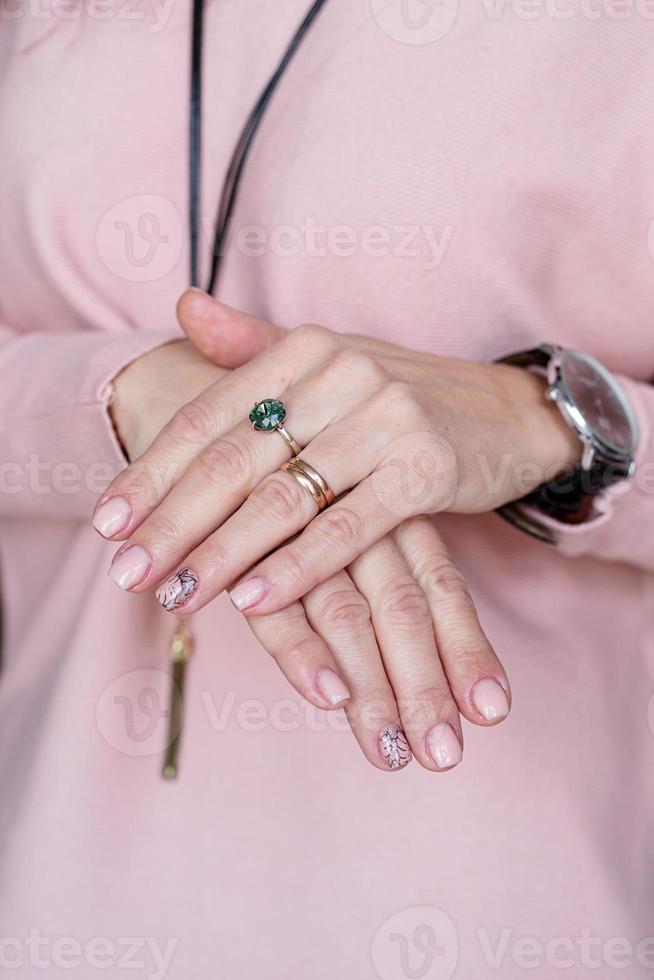 mano femminile con manicure rosa pastello appena fatta foto