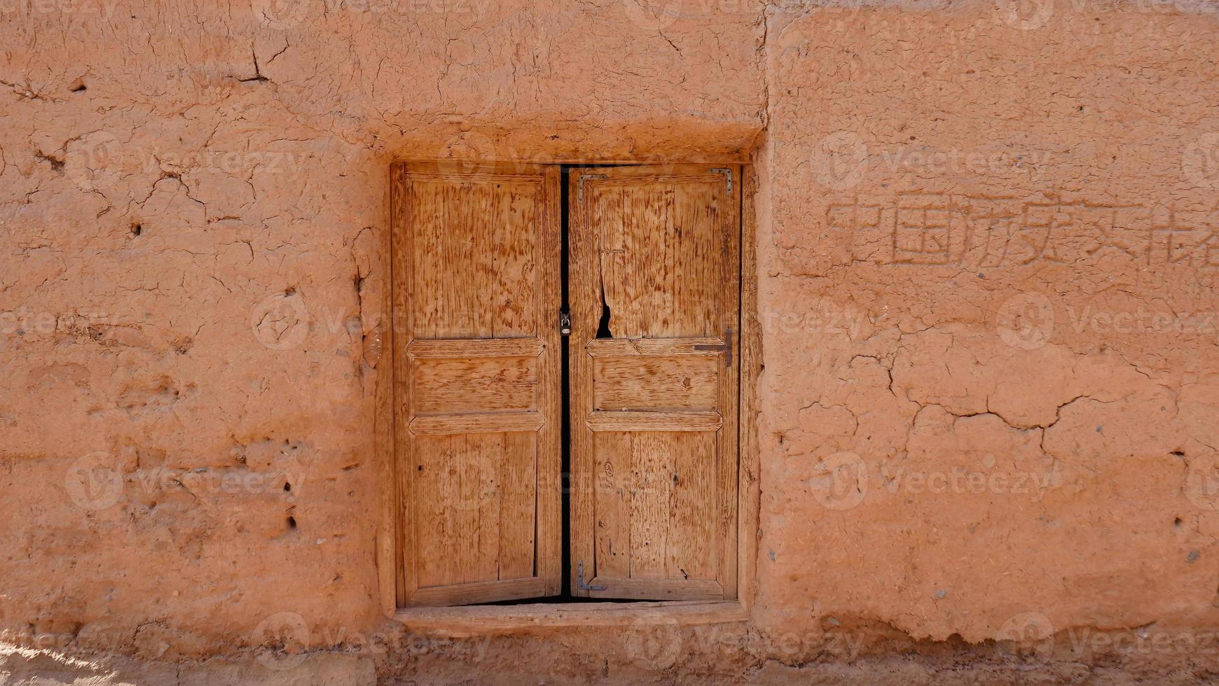 vecchia porta di legno della parete della casa nella valle del villaggio di tuyoq xinjiang cina. foto