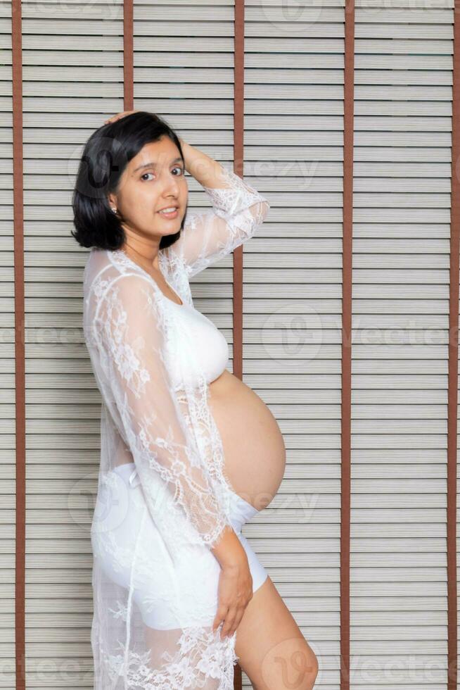 ritratto di un' incinta donna toccante sua grande pancia vicino su, madre, gravidanza, persone e aspettativa. donna Tenere grande incinta stomaco foto