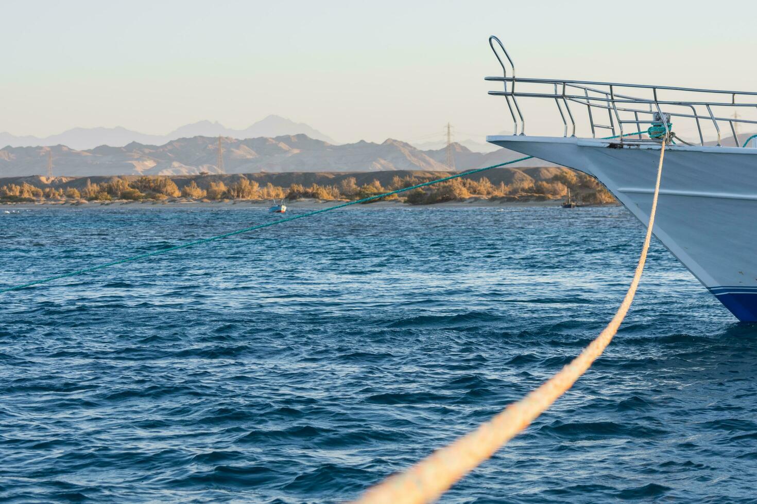 lungo corda a partire dal il attaccamento per un' bianca barca a il mare foto