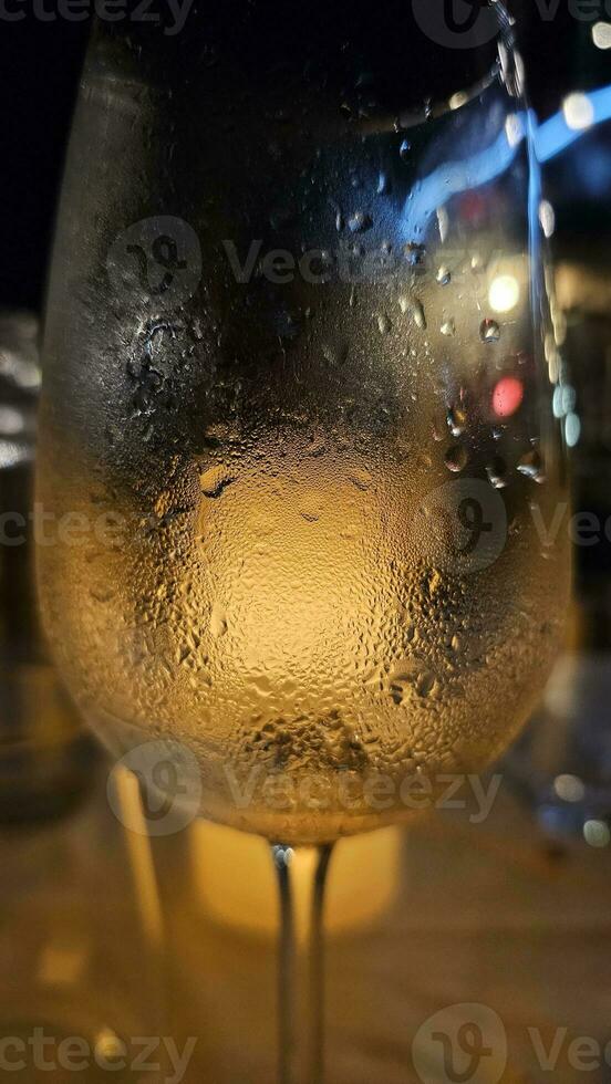 bicchiere di bianca vino servito con un' raffreddato bicchiere nel un' ristorante su il ligure Riviera nel estate nel 2023 foto