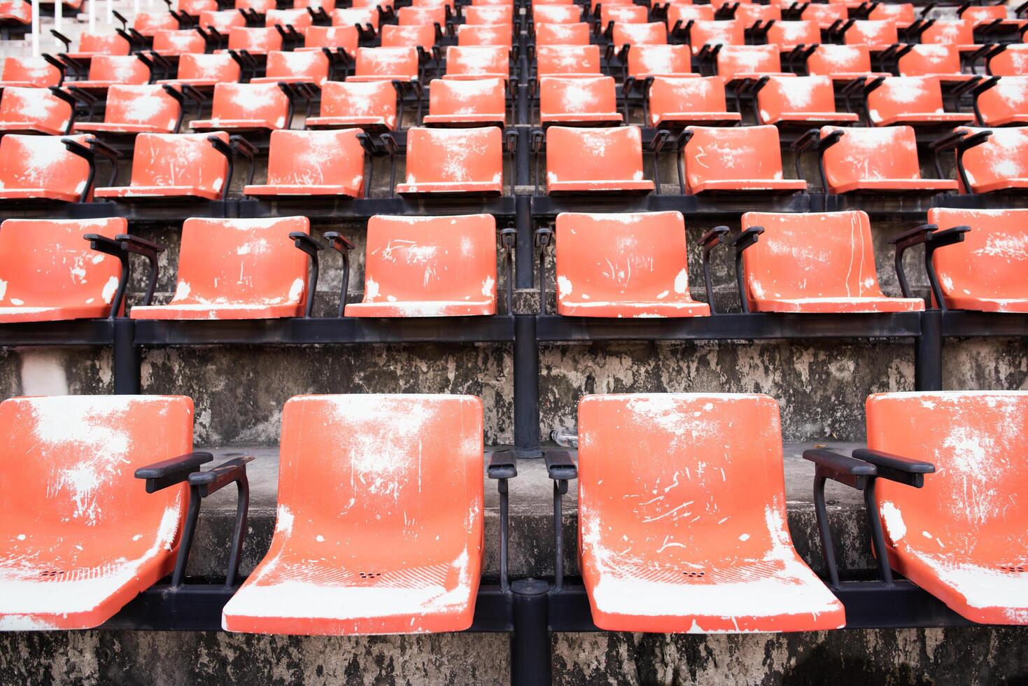 sedili di plastica vuoti e vecchi rossi nello stadio. foto