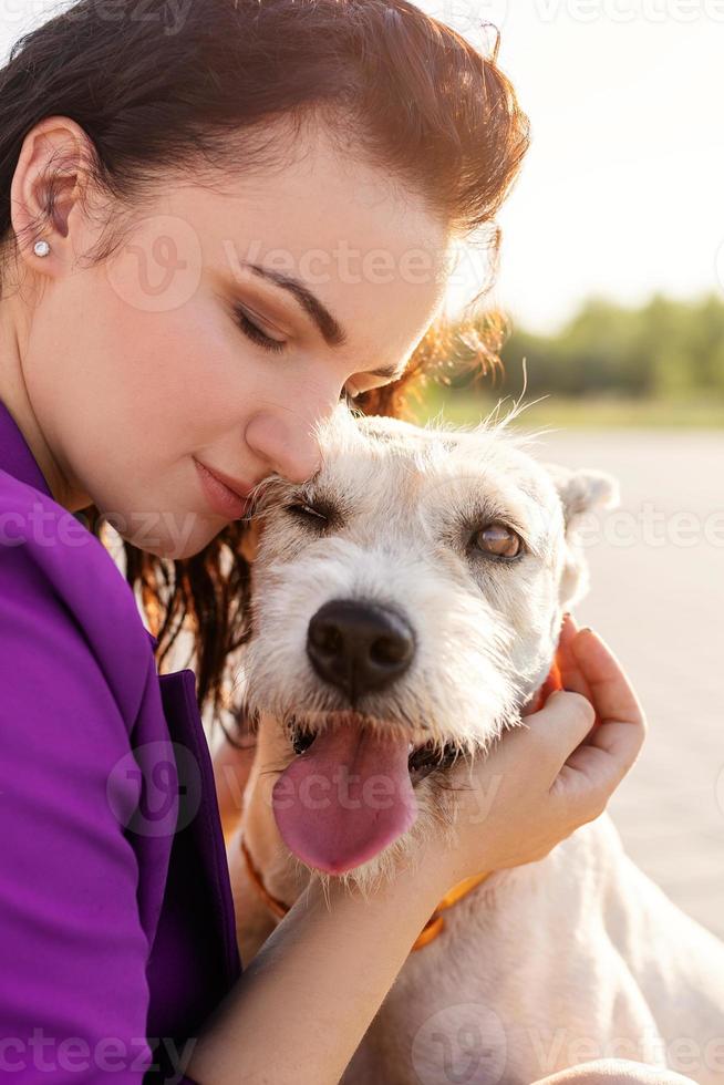 giovane donna attraente che abbraccia il suo cane nel parco? foto