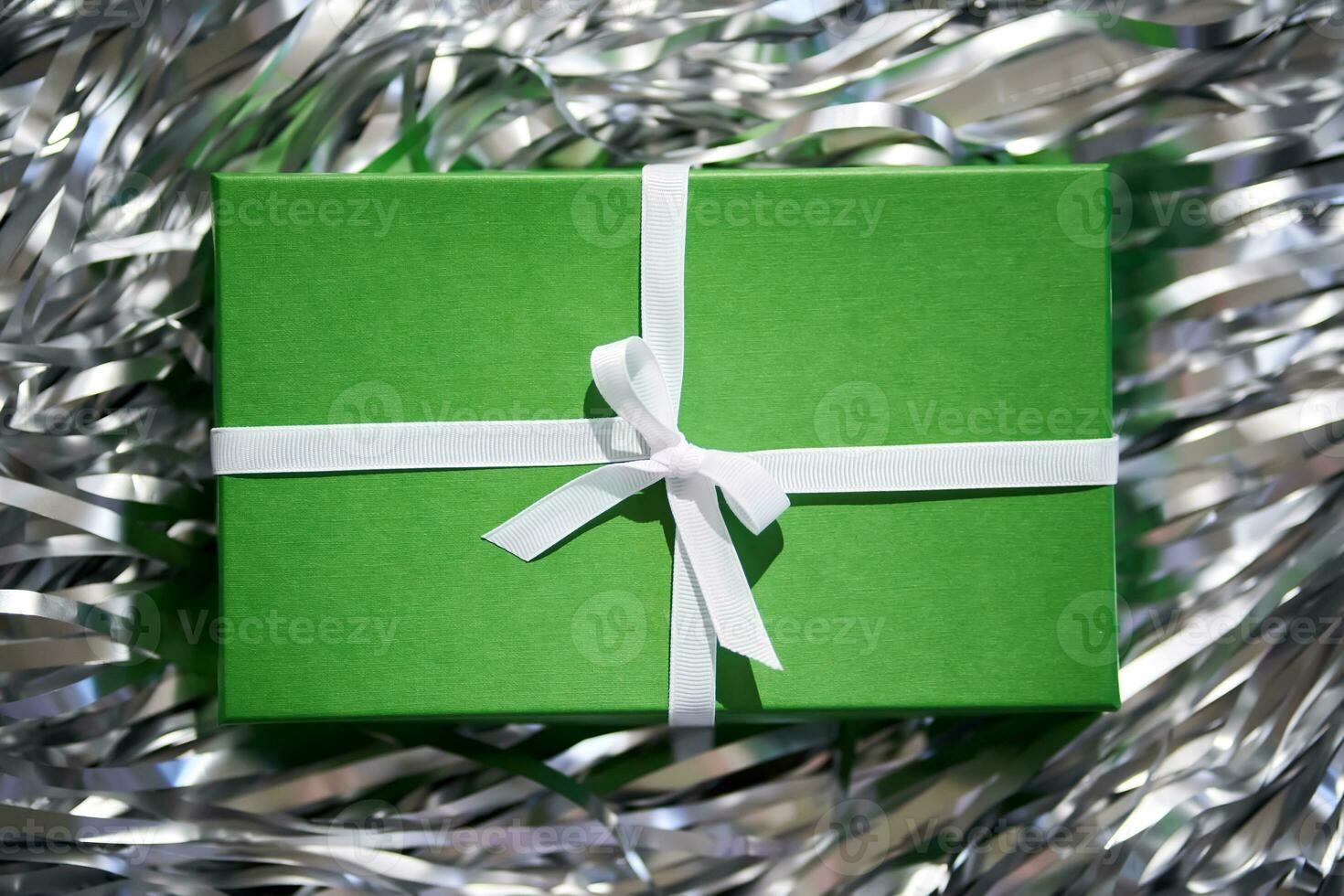 verde scatola con i regali su un' grigio sfondo. foto