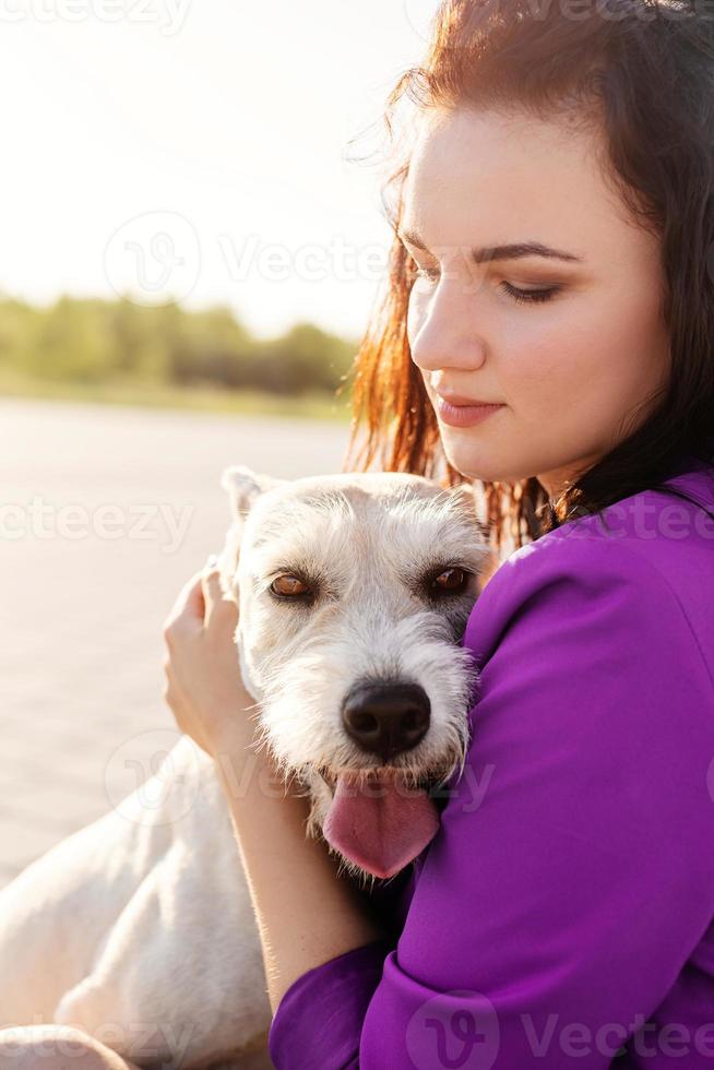 giovane donna attraente che abbraccia il suo cane nel parco? foto