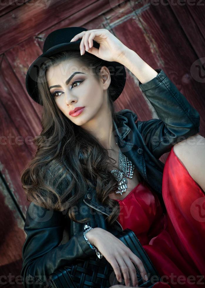 giovane bella donna bruna con abito corto rosso e cappello nero foto