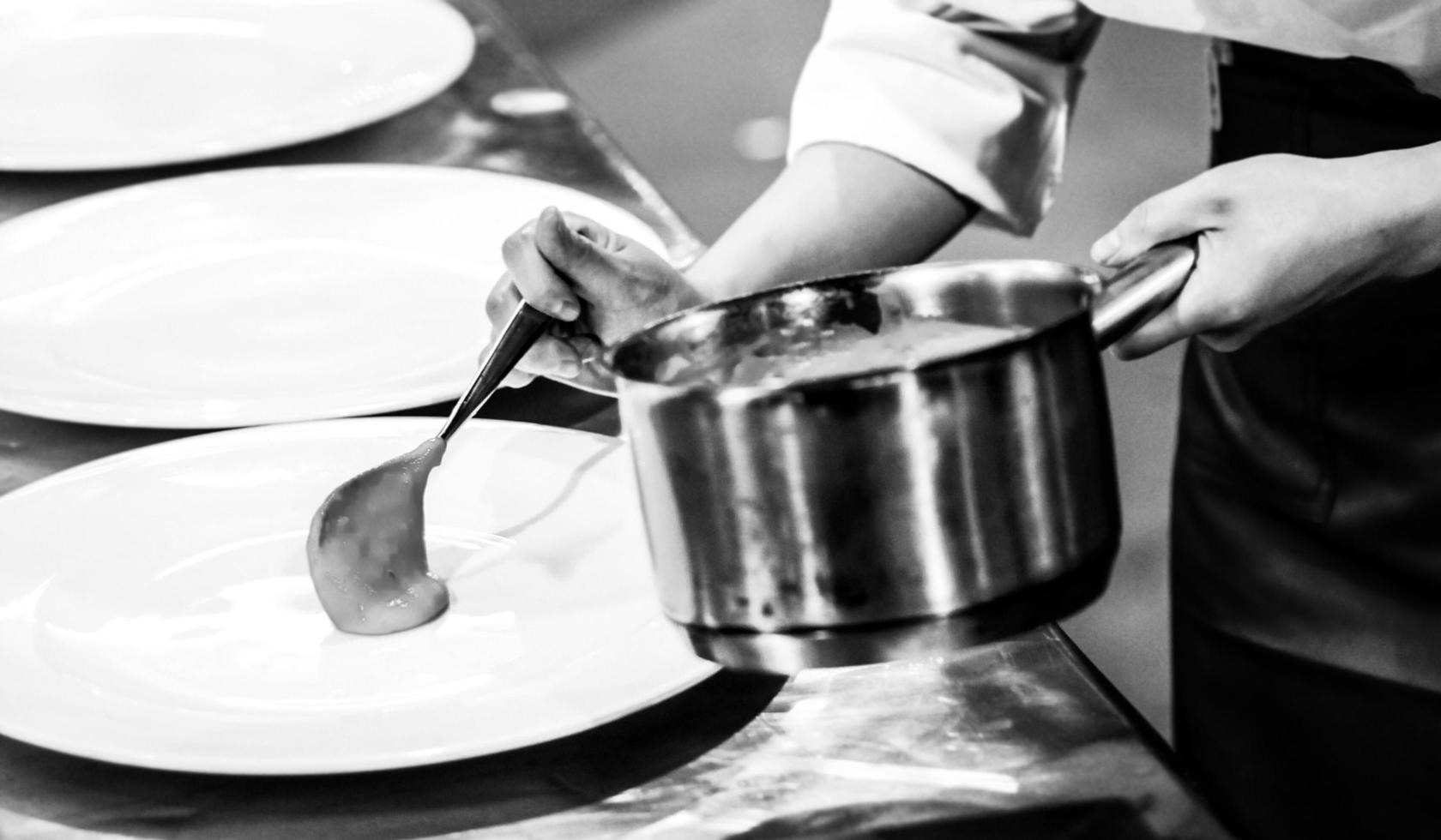 chef che cucina in una cucina, chef al lavoro, bianco e nero foto