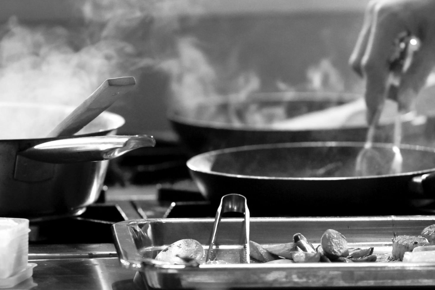 chef che cucina, chef che prepara il cibo, chef che decora il piatto in cucina foto