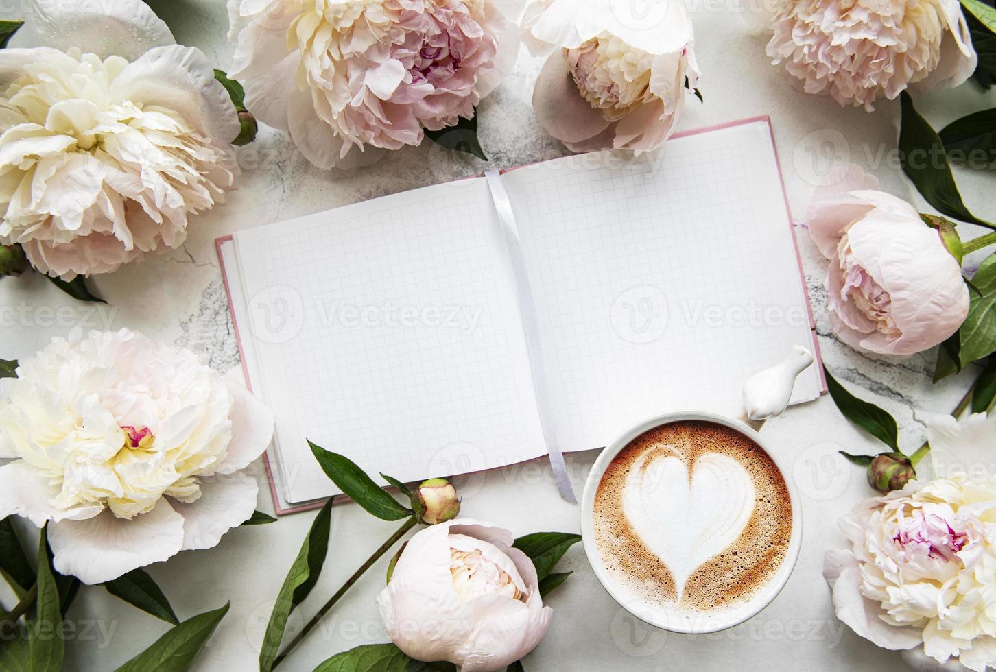 fiori di peonia, taccuino e caffè foto