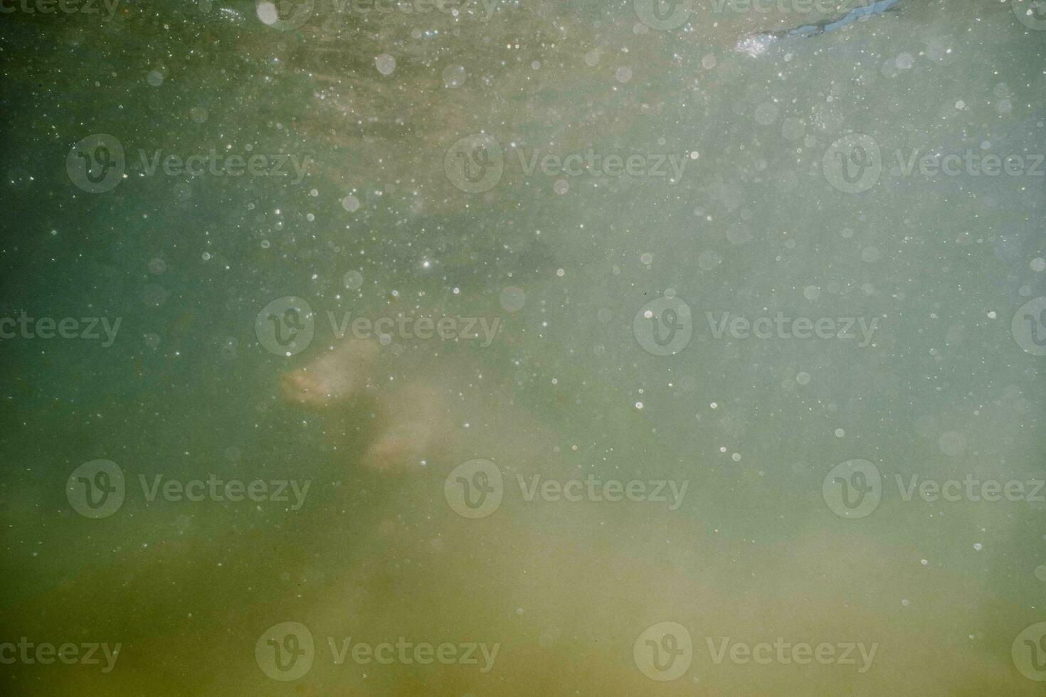 un' persona nuoto sotto acqua con bolle In arrivo a partire dal il superficie foto