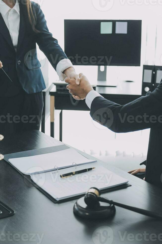 uomo d'affari che stringe la mano per sigillare un accordo con i suoi avvocati o avvocati partner che discutono di un accordo contrattuale foto