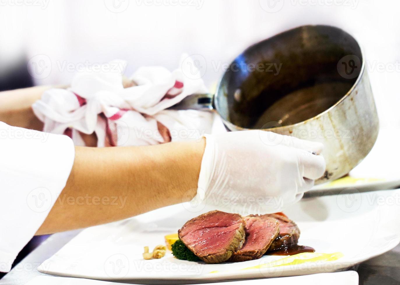 chef che prepara il cibo in cucina, chef che cucina, chef che decora il piatto foto