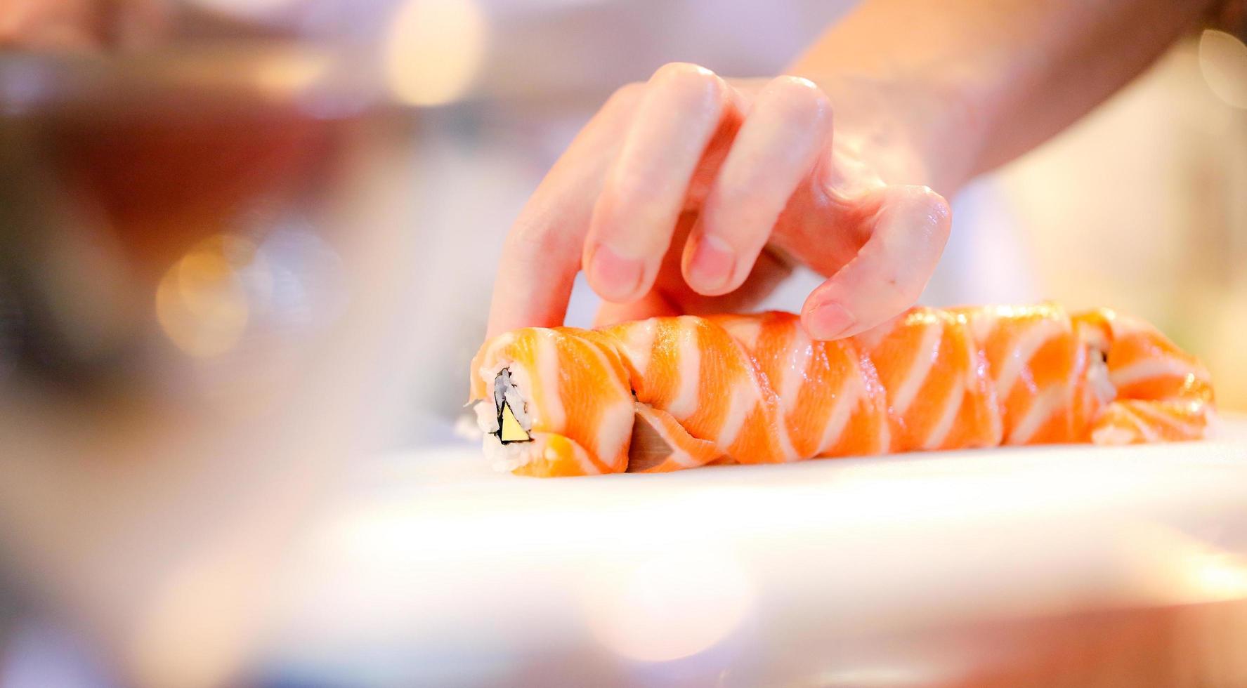 mani dello chef che preparano cibo giapponese, chef che prepara sushi foto