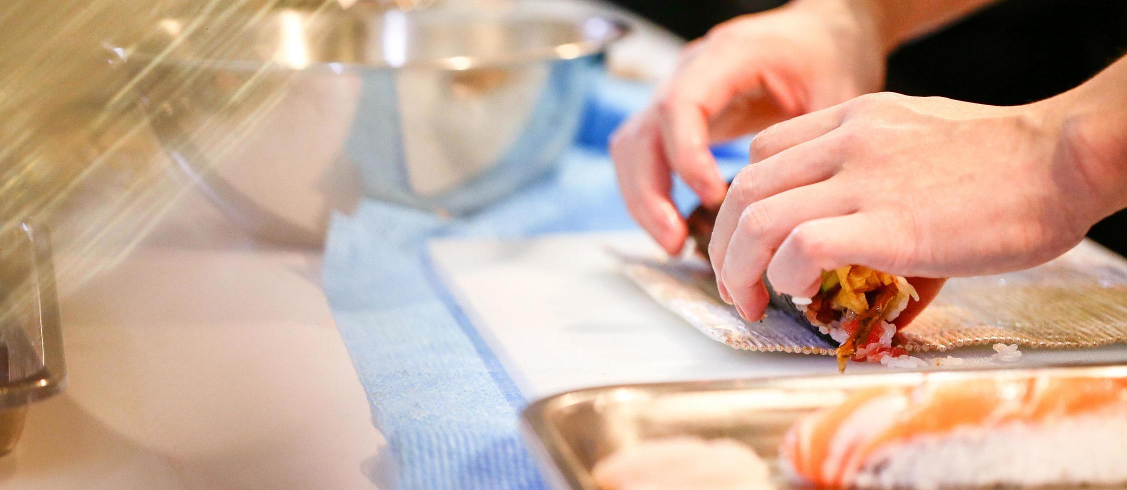 mani dello chef che preparano cibo giapponese, chef che prepara sushi foto