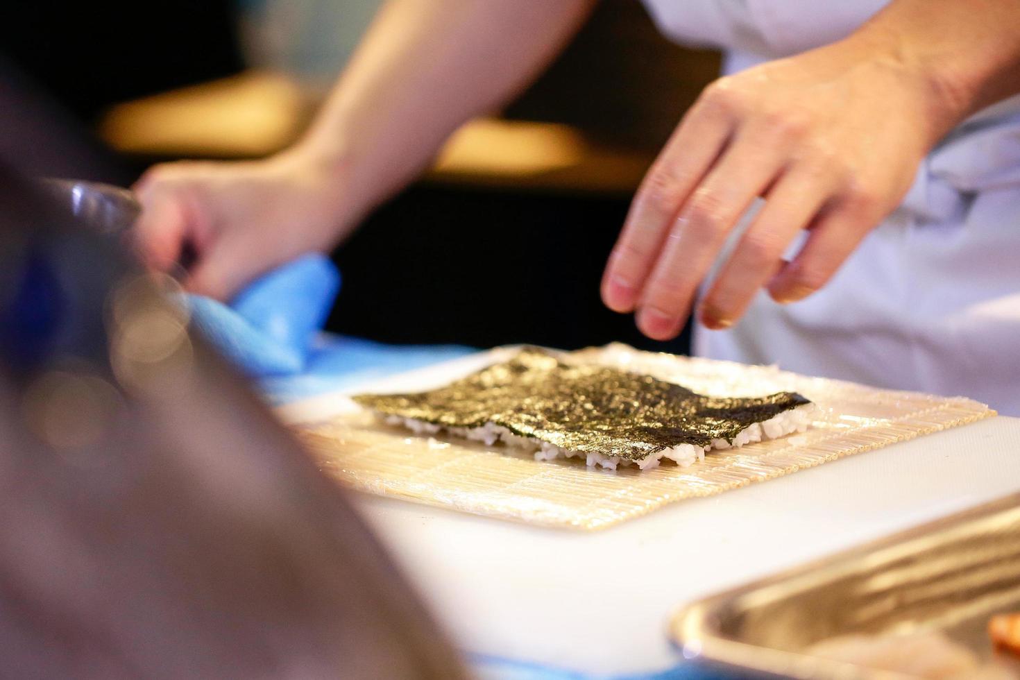 mani dello chef che preparano cibo giapponese, chef che prepara sushi foto