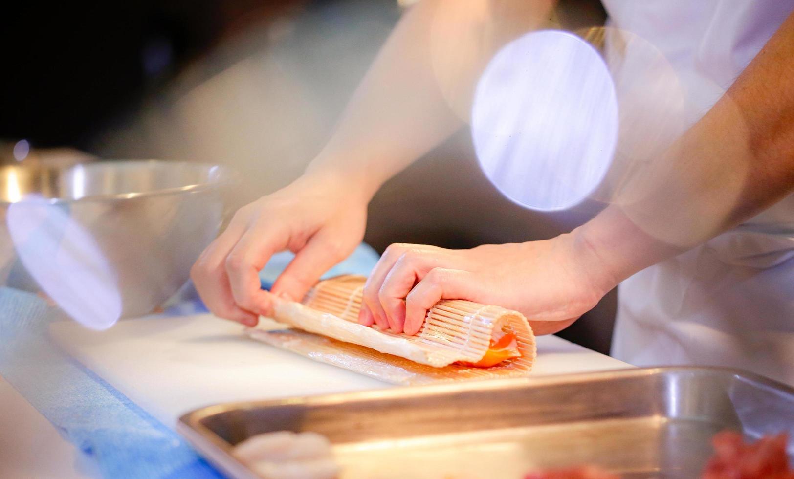 mani dello chef che preparano cibo giapponese, chef che prepara sushi foto