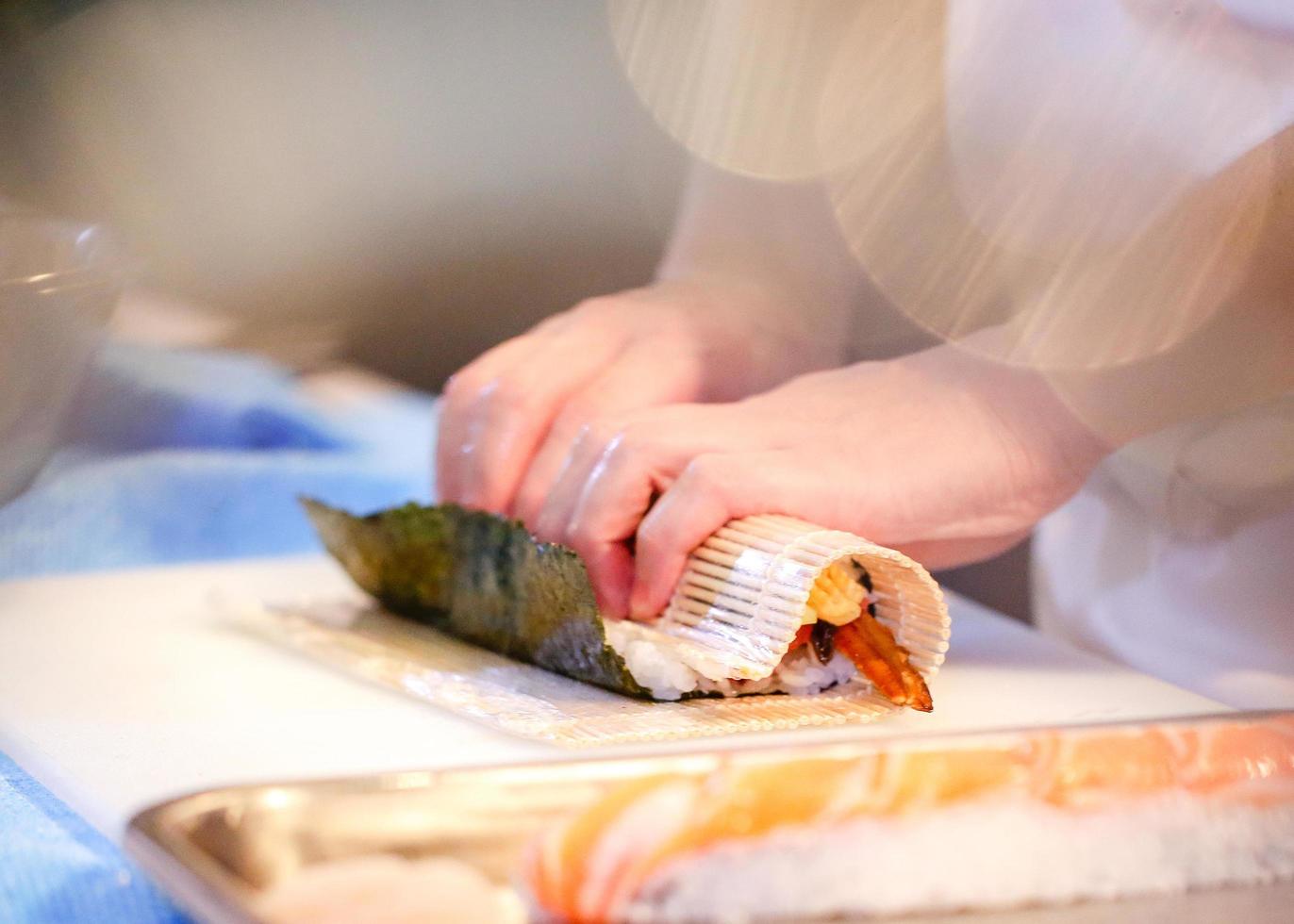 mani dello chef che preparano cibo giapponese, chef che prepara sushi foto