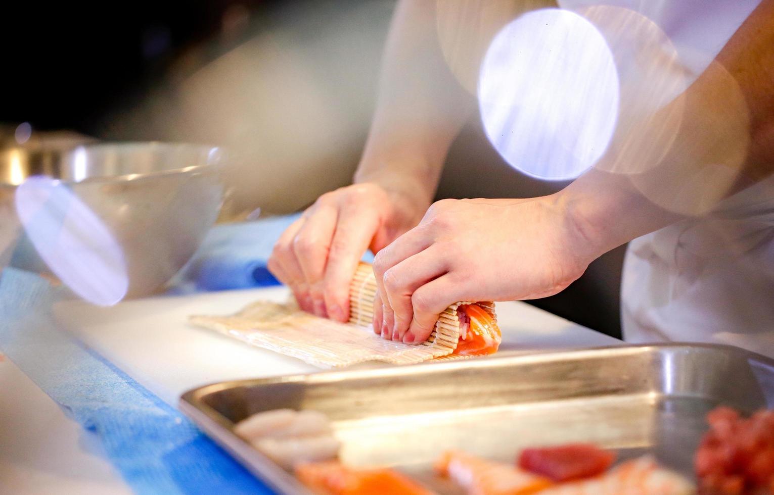 mani dello chef che preparano cibo giapponese, chef che prepara sushi foto