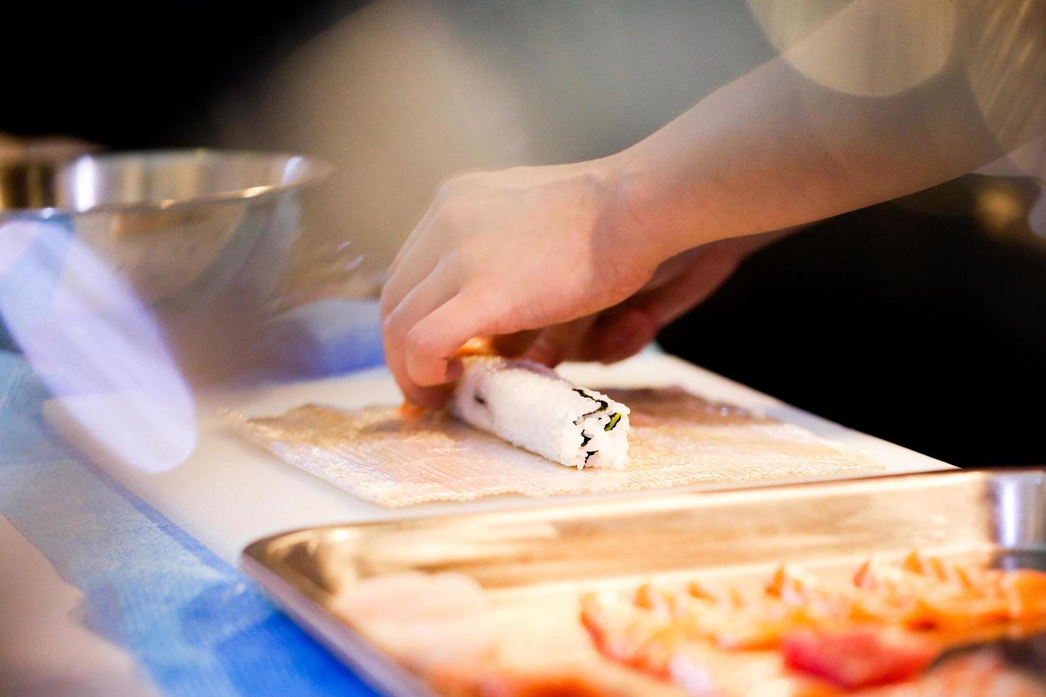 mani dello chef che preparano cibo giapponese, chef che prepara sushi foto