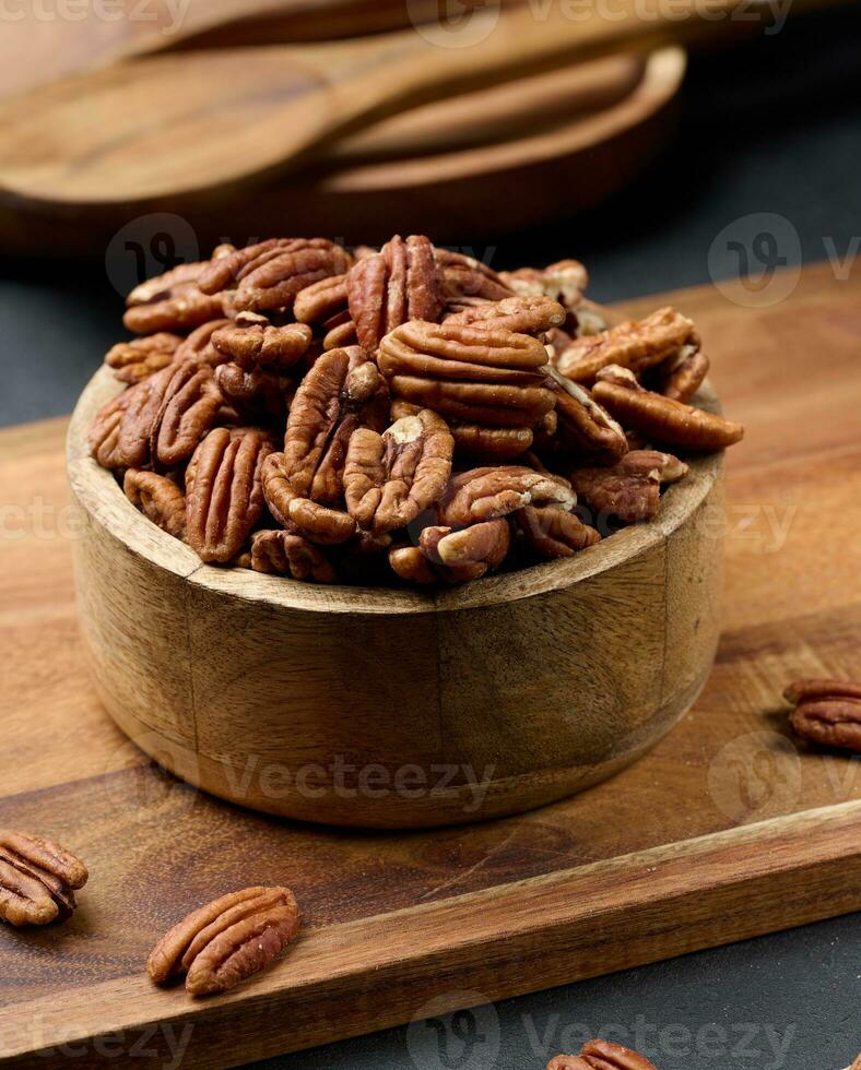 sgusciate Noci Pecan nel un' il giro di legno piatto foto