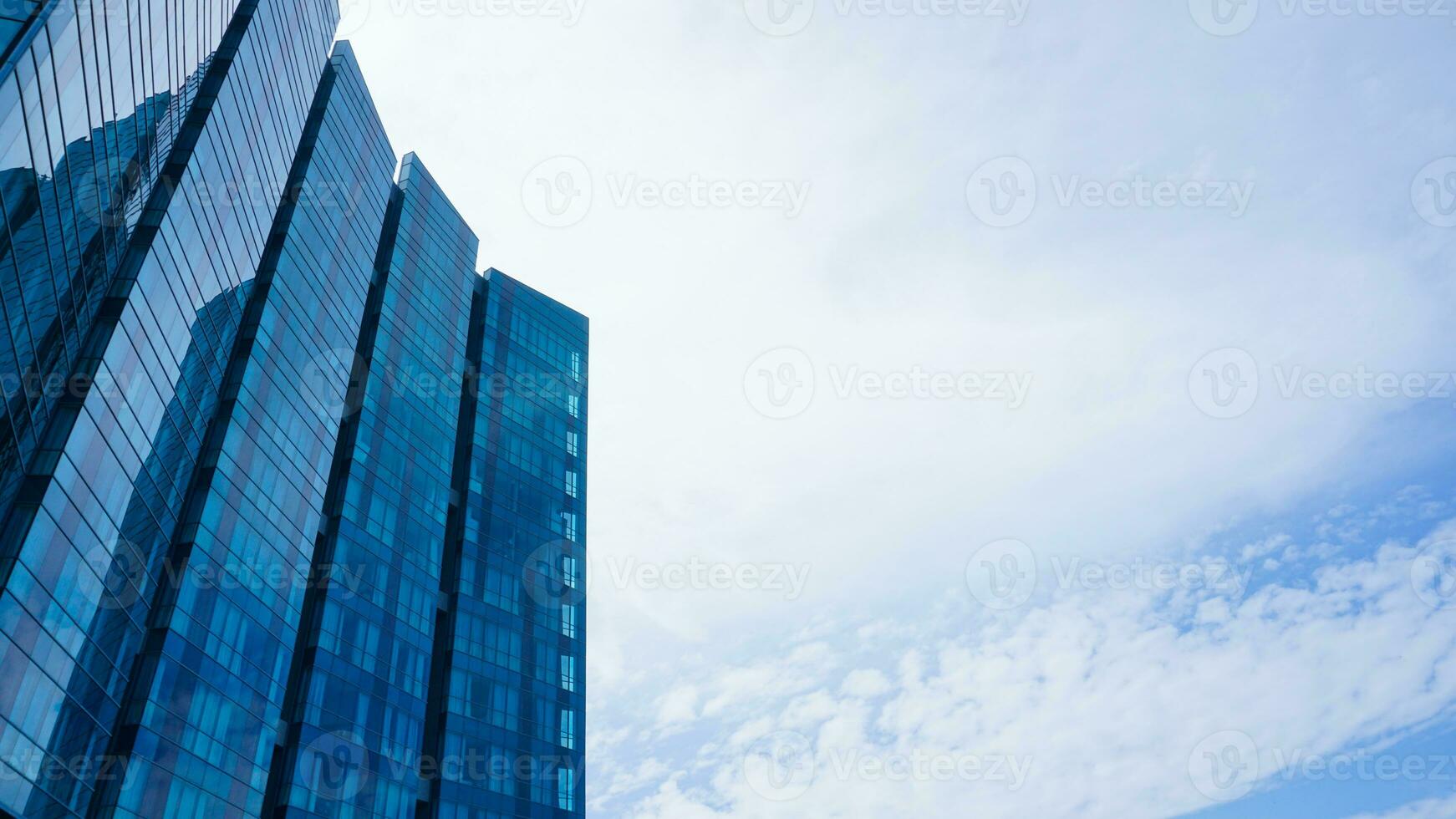 parte inferiore Visualizza blu bicchieri edificio con cielo e nube sfondo. grattacielo, Visualizza di moderno attività commerciale costruzione. modello moderno blu bicchieri edificio paesaggio. guardare su prospettiva. copia spazio foto