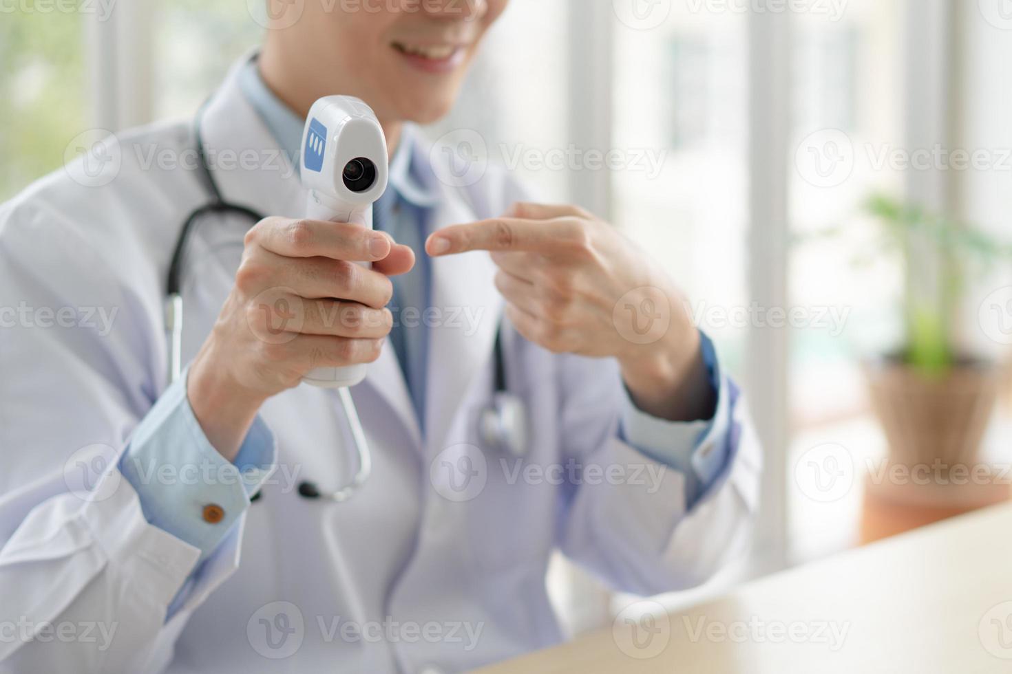 medico che insegna al paziente a usare il termometro digitale foto