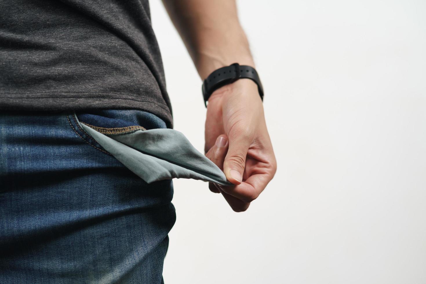 uomo che tira fuori la tasca dei jeans per mostrare la tasca vuota. bancarotta. foto