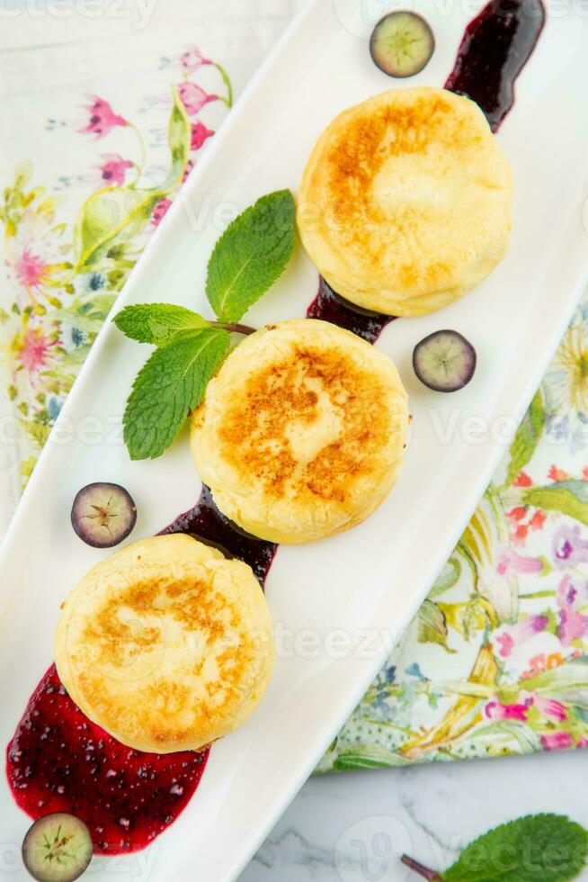 lussureggiante e alto cheesecake con marmellata e menta su un' bianca piatto superiore Visualizza foto