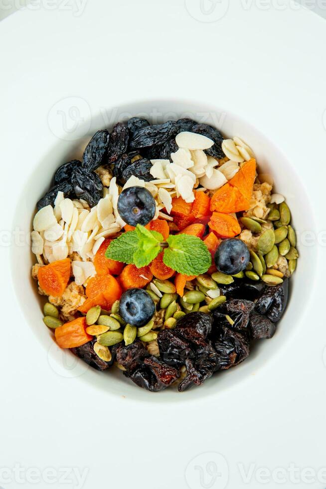in profondità piatto con cereali, frutti di bosco, pistacchi, secco albicocche e uva passa superiore Visualizza foto
