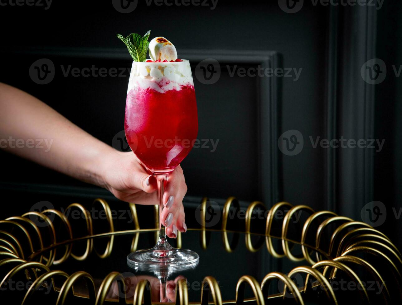 rosso cocktail su un' buio sfondo con frustato crema guarnizione foto