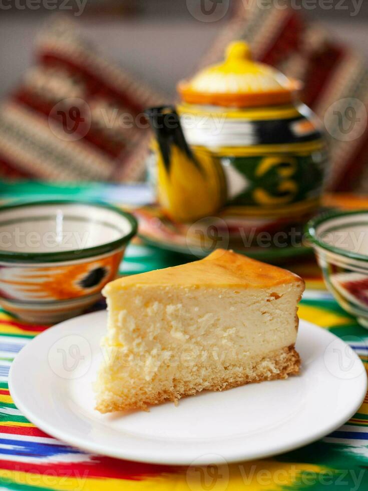 dolce torta di formaggio nel orientale stile con un' teiera e un' tazza per tè. foto