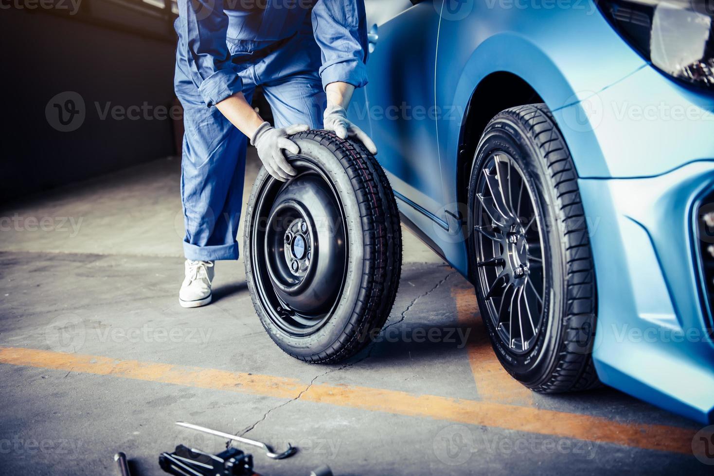 i meccanici dell'auto cambiano la gomma nel garage dell'officina di riparazioni auto foto