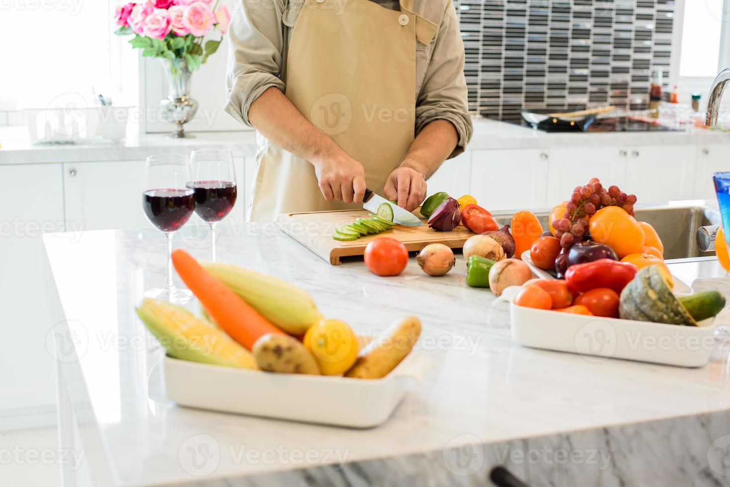 uomo che cucina e affetta le verdure in cucina foto