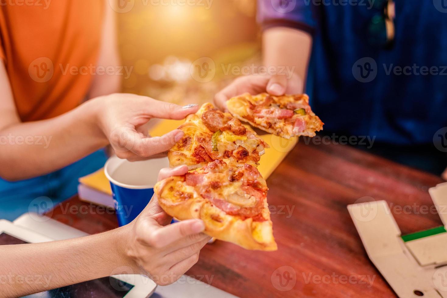 gente che festeggia con la pizza in mano foto