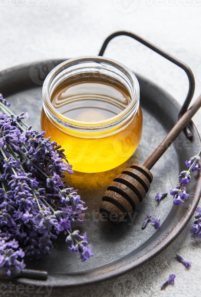 vasetto con miele e fiori di lavanda fresca foto